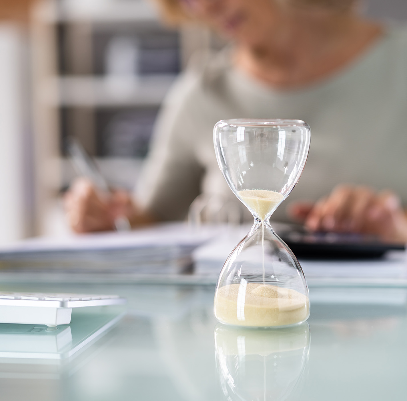 Image: depositphotos.com Image of hourglass and woman working